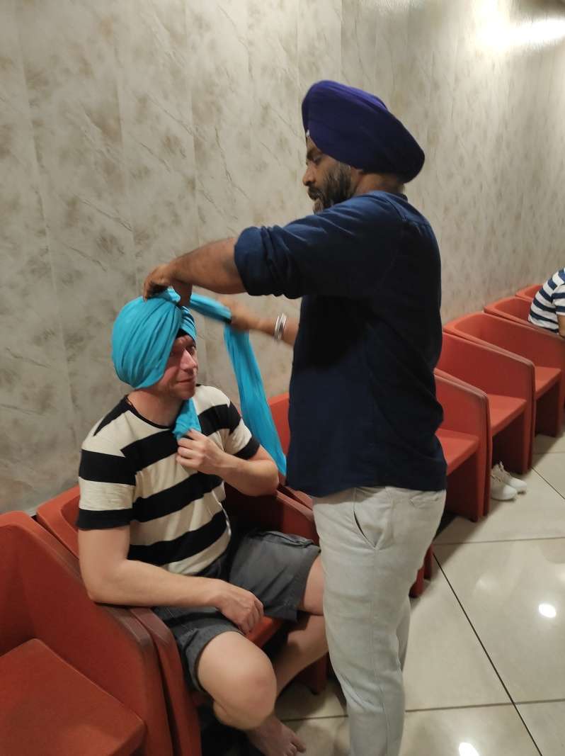 Sikhský chrám Grurdwara Bangla Sahib - chlapci si kúpili turbany, Sikh im ich uviazal