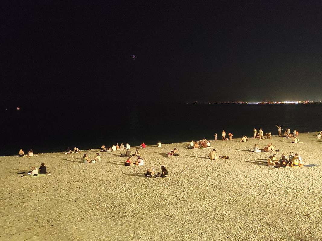 Pláž v Nice a svietiace štartujúce lietadlo