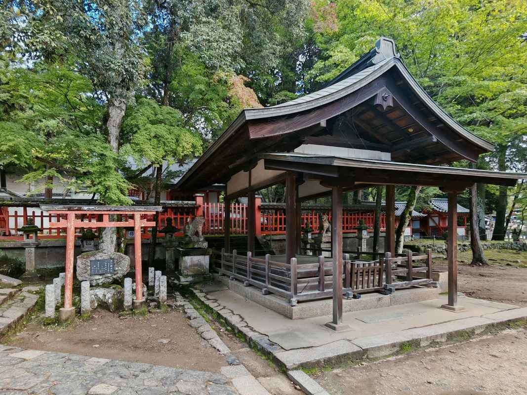 Šintoistická svätyňa Tamukeyama Hachiman Shrine, vľavo kameň, na ktorom sedel básnik Sugawara
